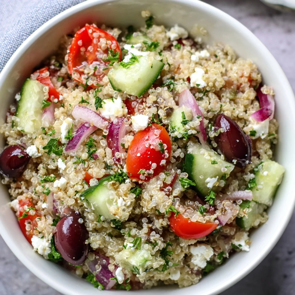 Serving suggestion for Mediterranean Quinoa Salad, plated with fresh parsley and a lemon wedge, perfect for a healthy lunch.