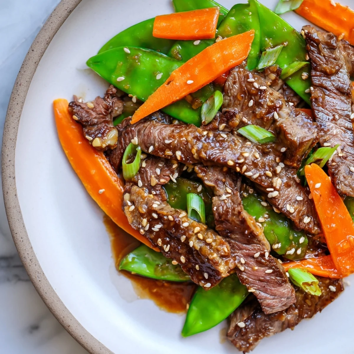 Beef Stir Fry with Snow Peas and Carrots features tender beef and crisp veggies coated in glossy, savory sauce.