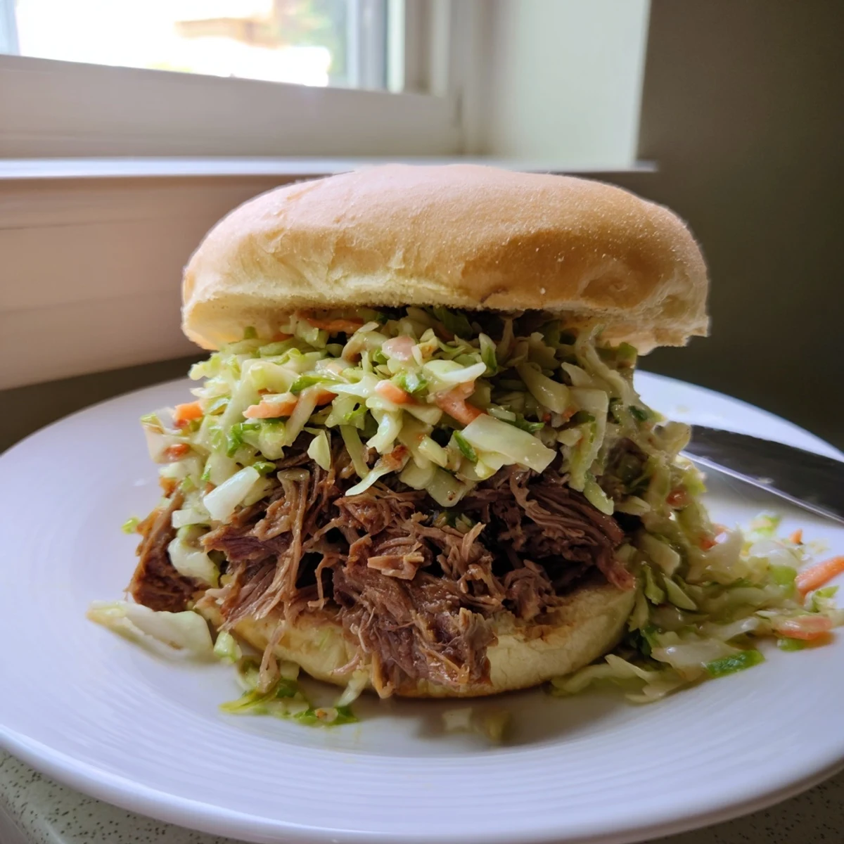 Golden-brown, tender pulled beef slow-cooked in a smoky barbecue sauce, piled high on a soft sandwich bun.