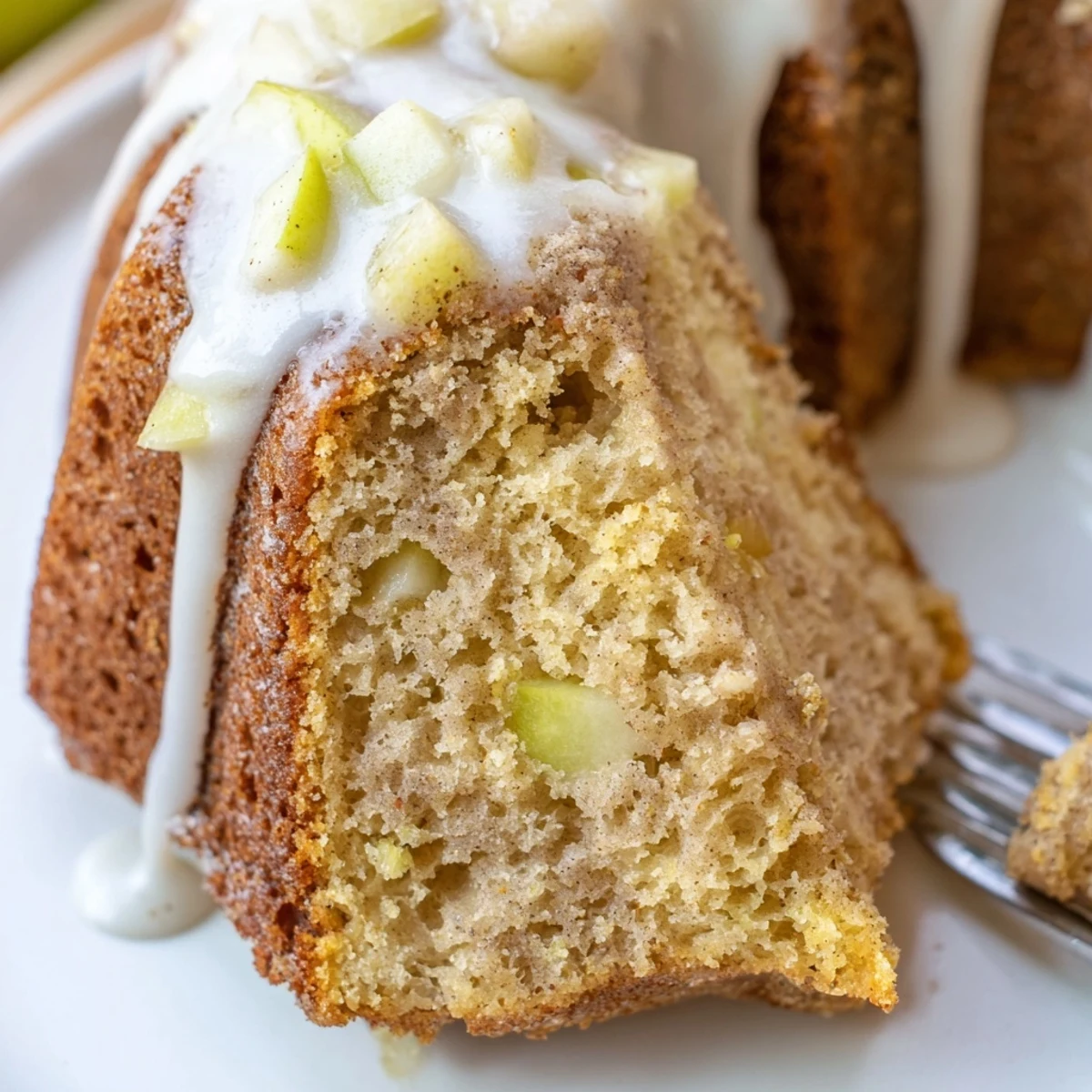 A freshly baked Spiced Apple Cider Bundt Cake with a golden crust sits on a cooling rack.
