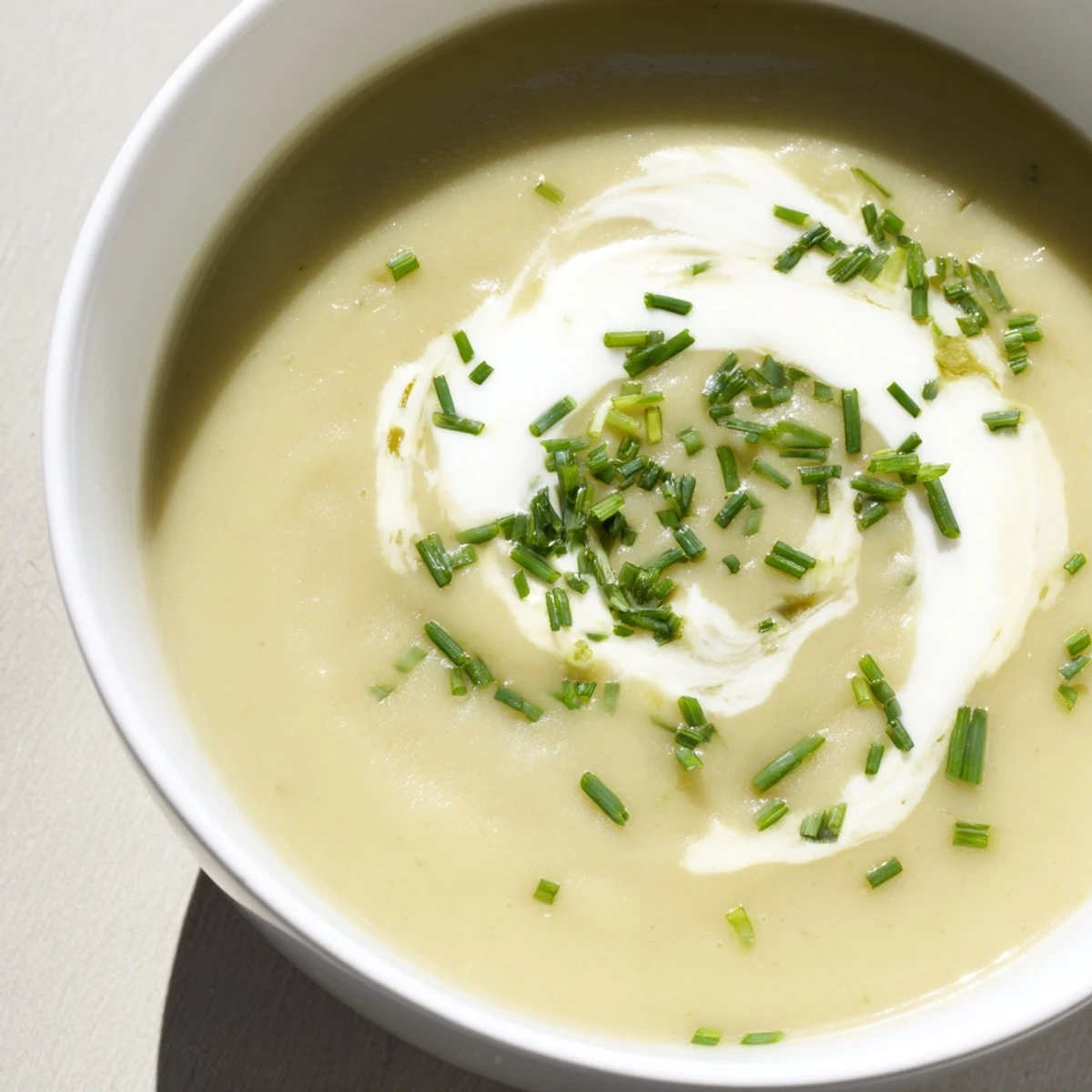 Creamy Leek Soup with Diced Potatoes served hot in a rustic bowl, garnished with fresh chives and a swirl of heavy cream.