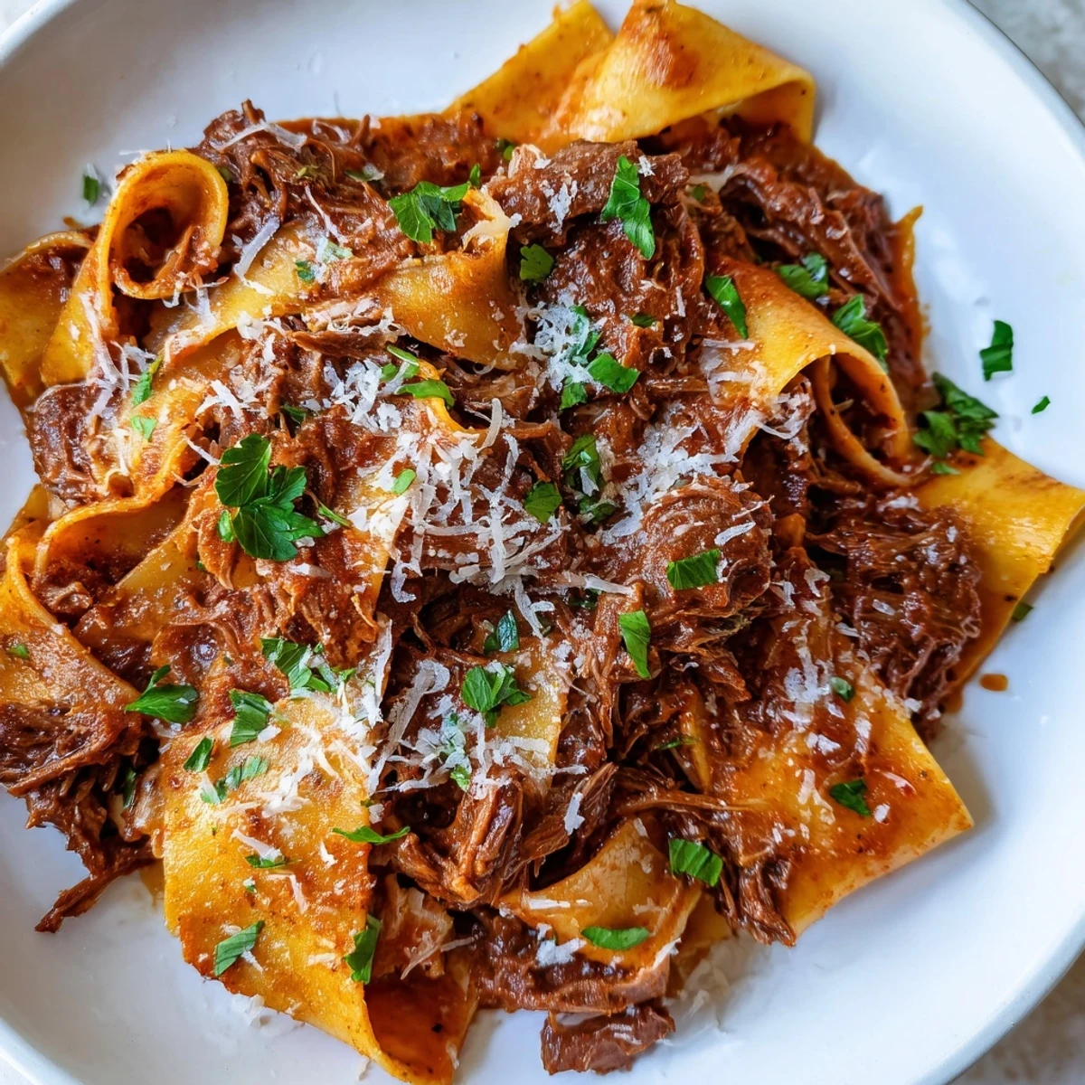 Garnished with fresh parsley and grated Parmesan cheese, this hearty Italian pasta dish is ready to serve.  
