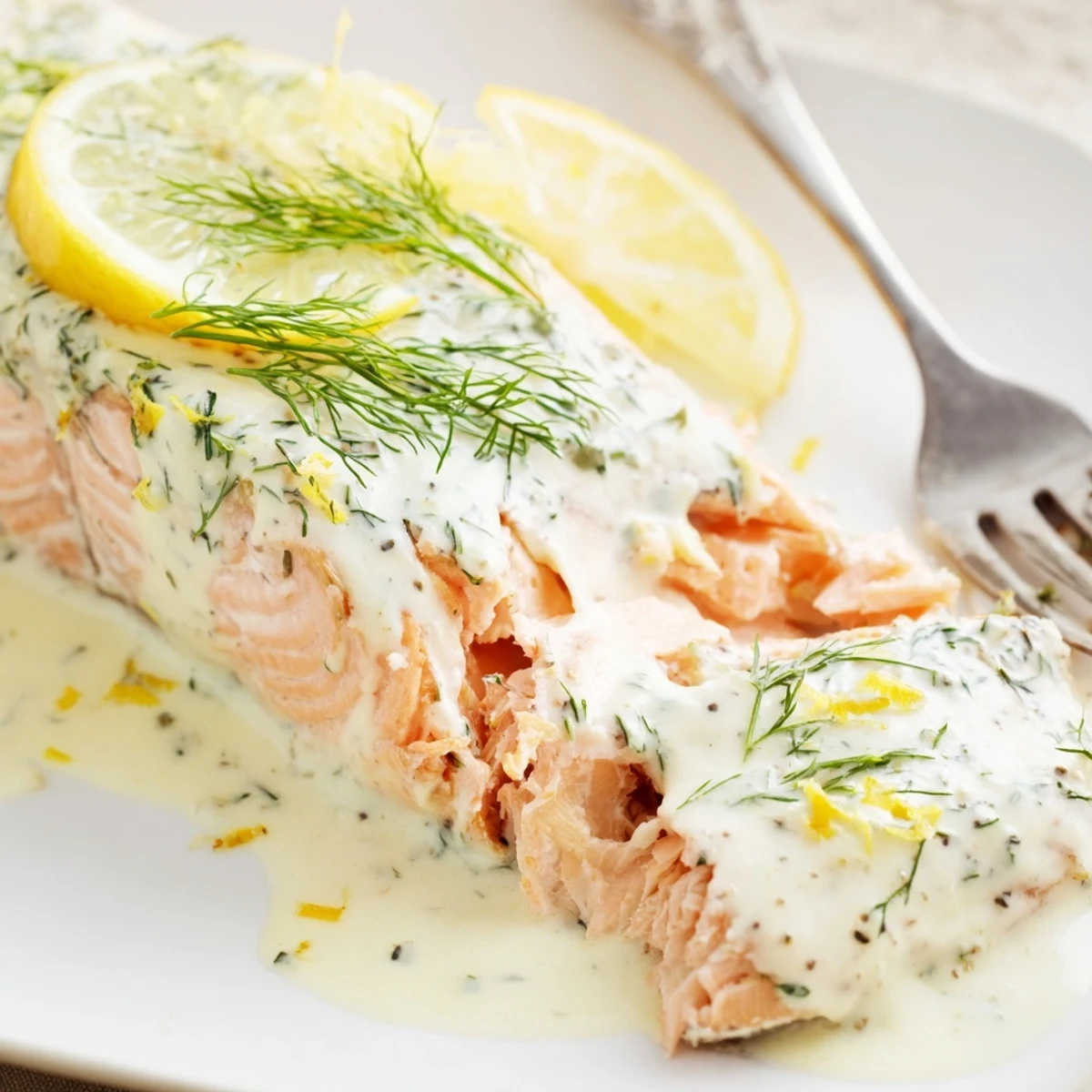 Golden-baked salmon fillets with vibrant lemon and dill sauce, ready to serve alongside colorful vegetables for a wholesome meal.