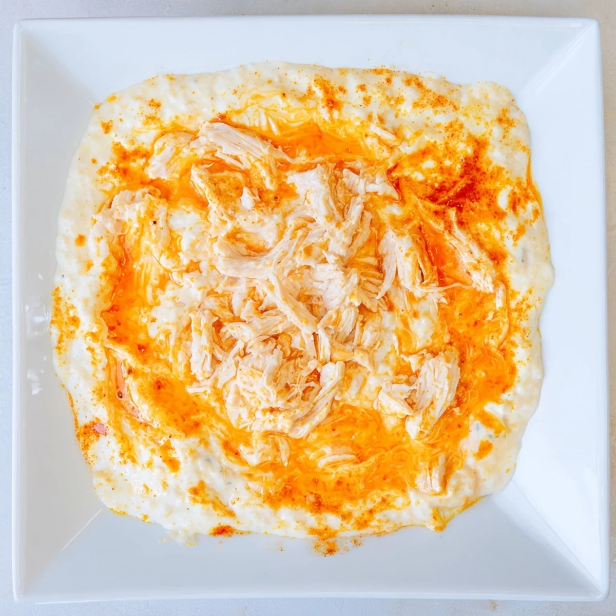 A savory party platter of Spicy Buffalo Chicken Dip served with crisp celery sticks, ideal for game day snacking.