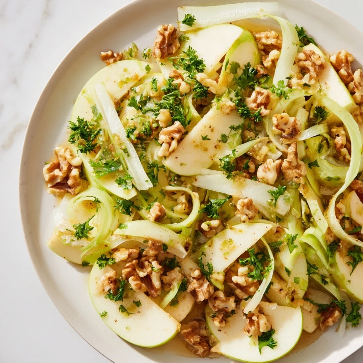 A crisp bowl of Apple and Celery Salad with Walnuts, showcasing bright green celery, sliced apples, and toasted nuts tossed in a light dressing.  