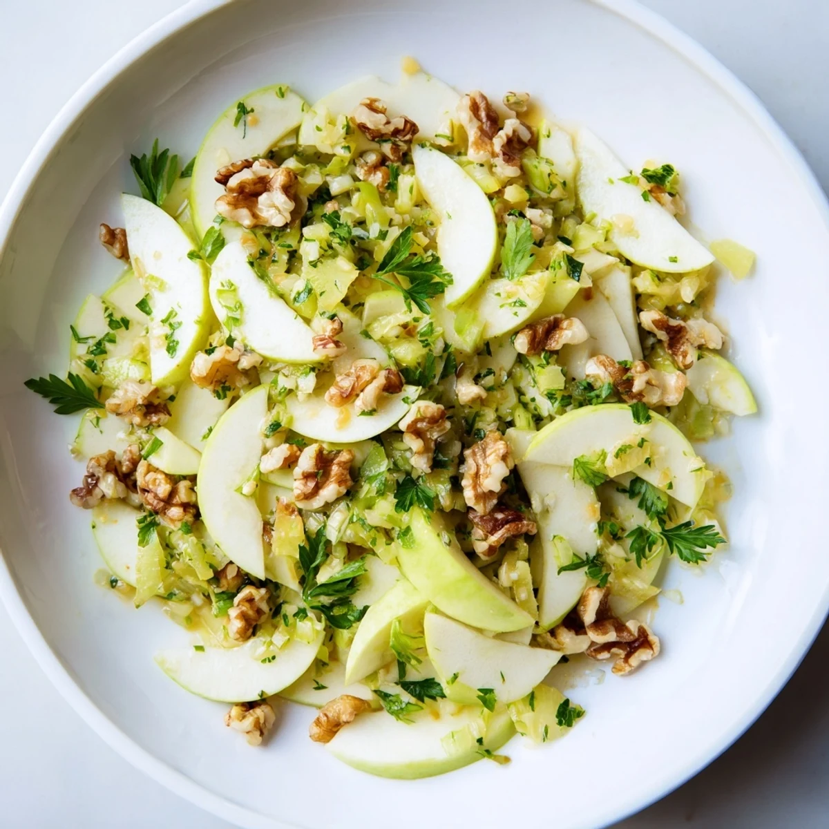 Vibrant Apple and Celery Salad with Walnuts features crisp apple slices, crunchy celery, and toasted nuts, drizzled with tangy dressing.