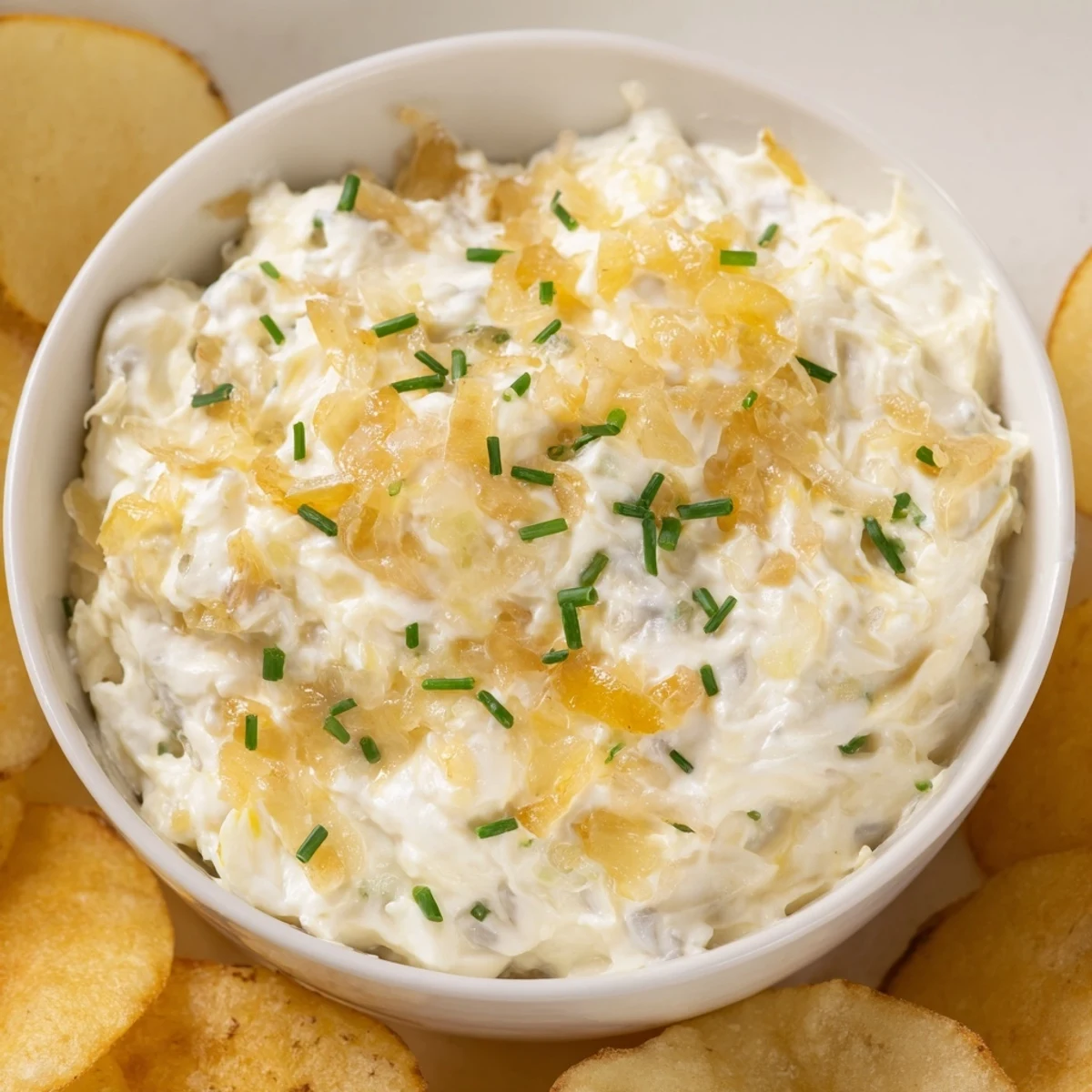 Caramelized onion dip made with sour cream and chives, paired with thick-cut potato chips for the ultimate savory game day snack.  