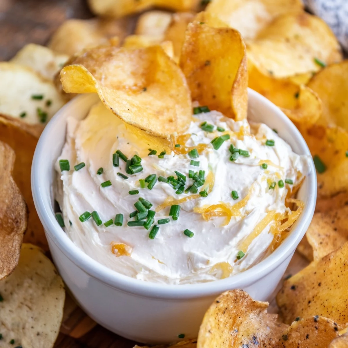 Golden potato chips served alongside rich onion dip, perfect for parties or game day.