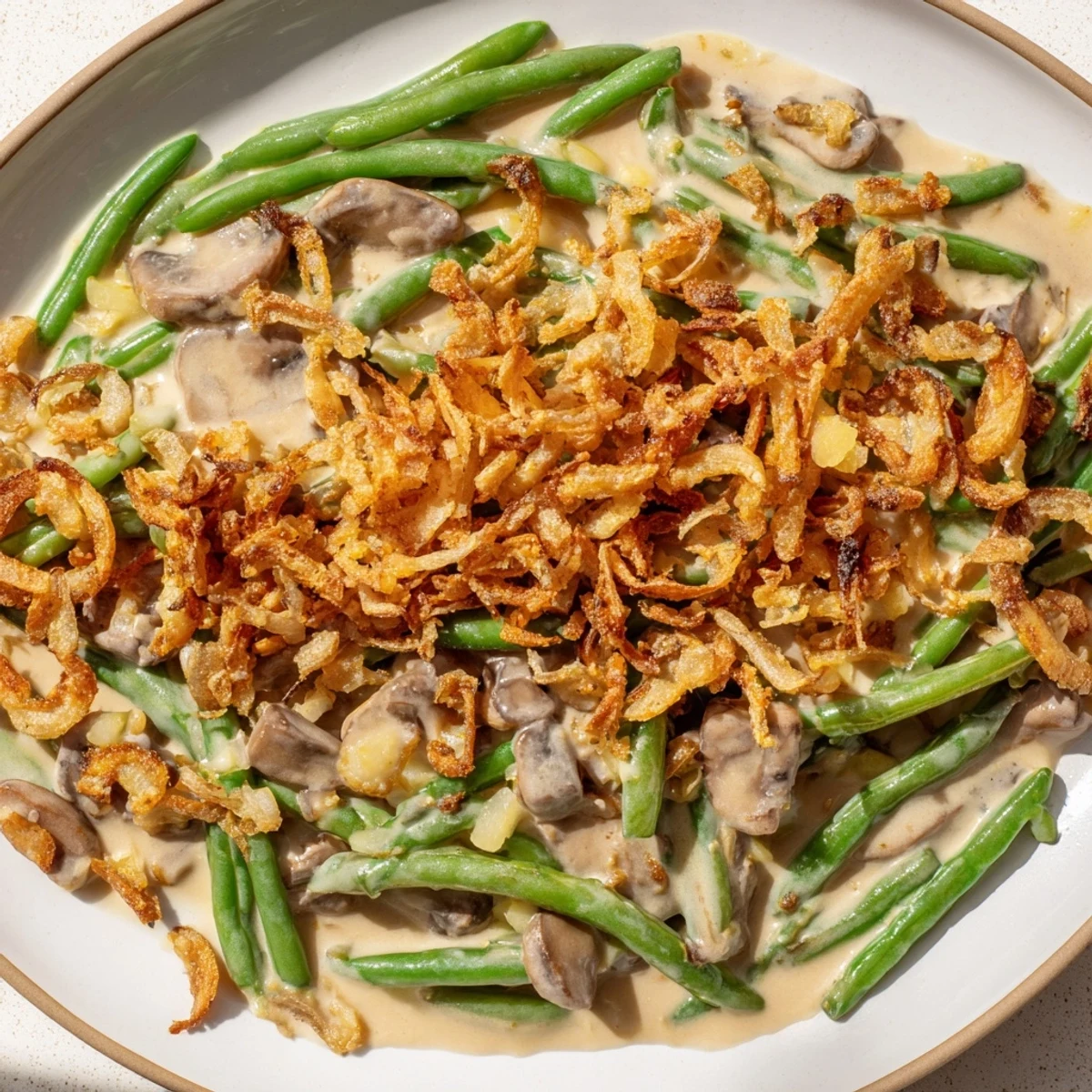 A freshly baked Green Bean Casserole with Crispy Onions, featuring tender green beans in a creamy mushroom sauce and topped with golden fried onions.