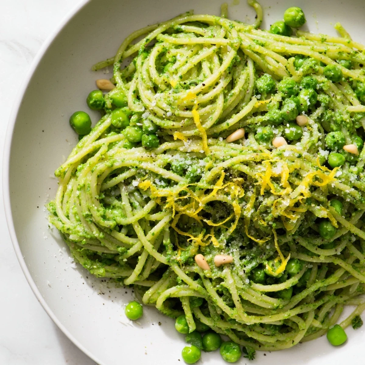 Spring Pea and Mint Pesto Pasta twirled on a fork, showing creamy pesto coating the strands.