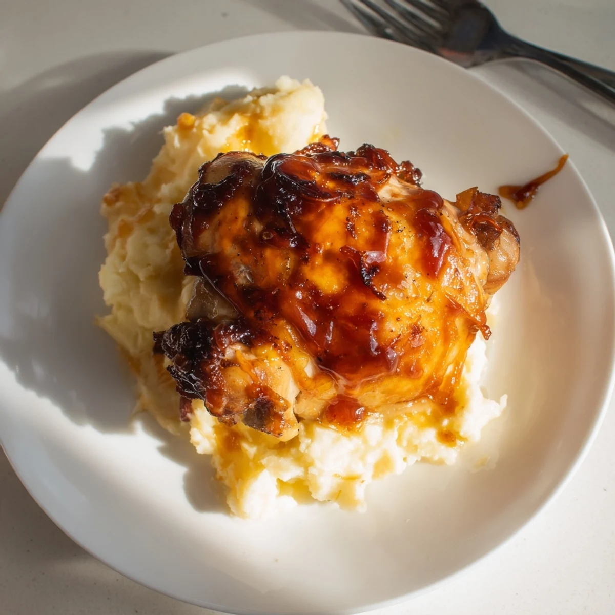 Savory chipotle honey chicken thighs glazed in a rich sauce paired with fluffy smoked Gouda potatoes and a parsley garnish.