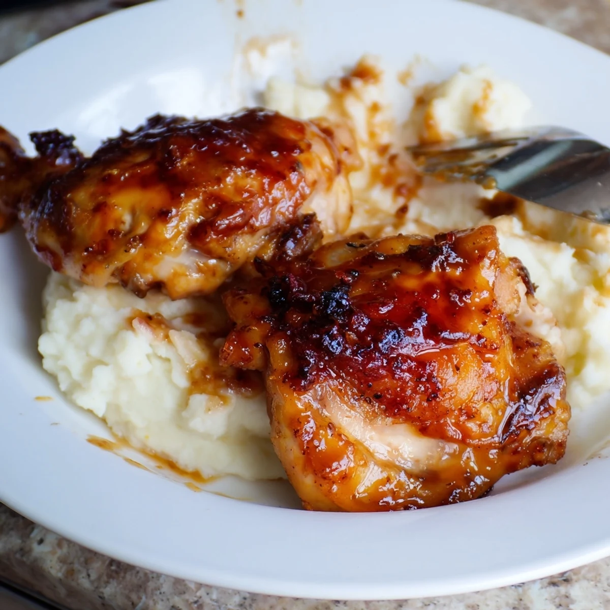 Roasted chipotle honey chicken thighs served over a bed of buttery smoked Gouda mashed potatoes with a side of greens.