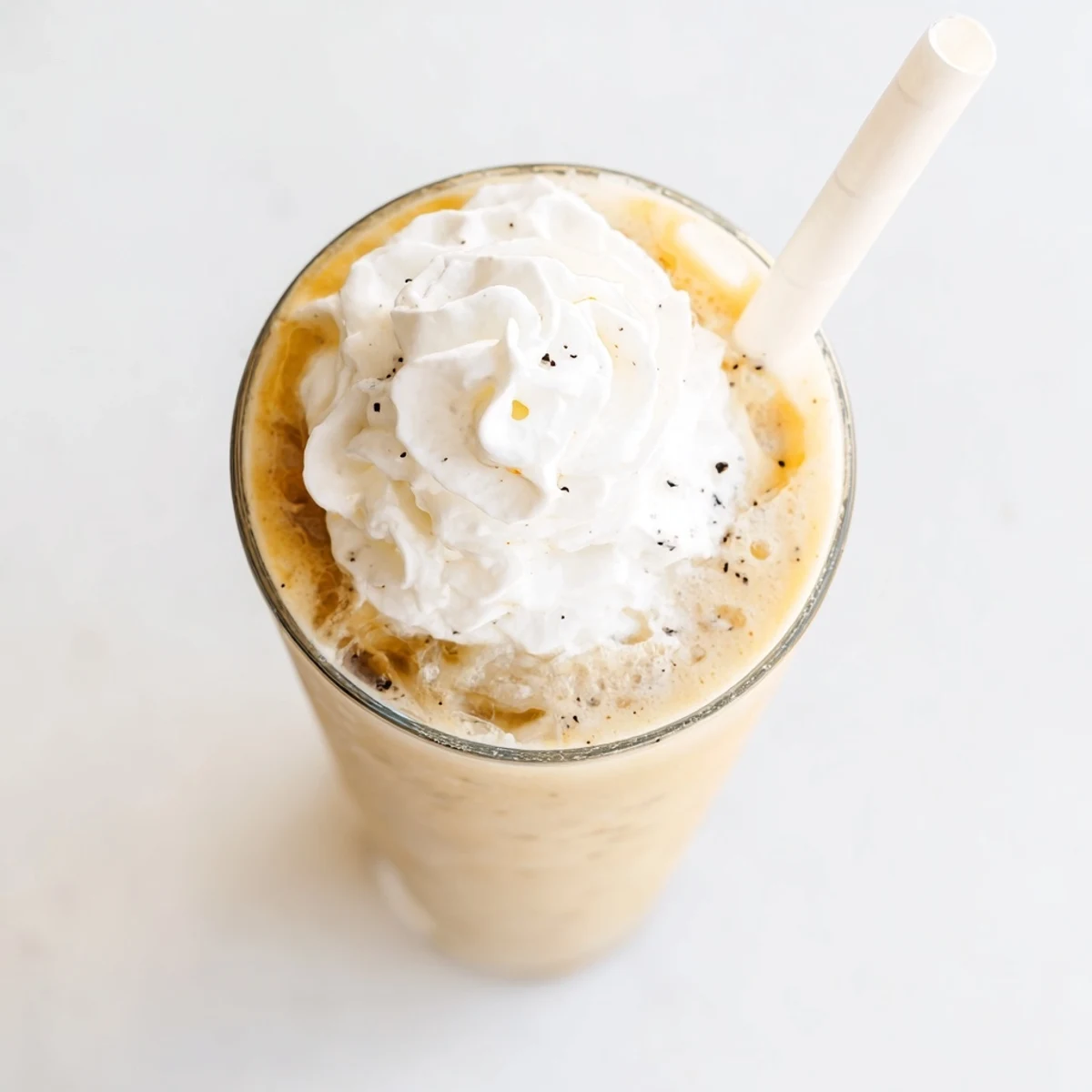 Homemade Vanilla Bean Frappuccino poured into a tall glass, ready to enjoy on a hot day.