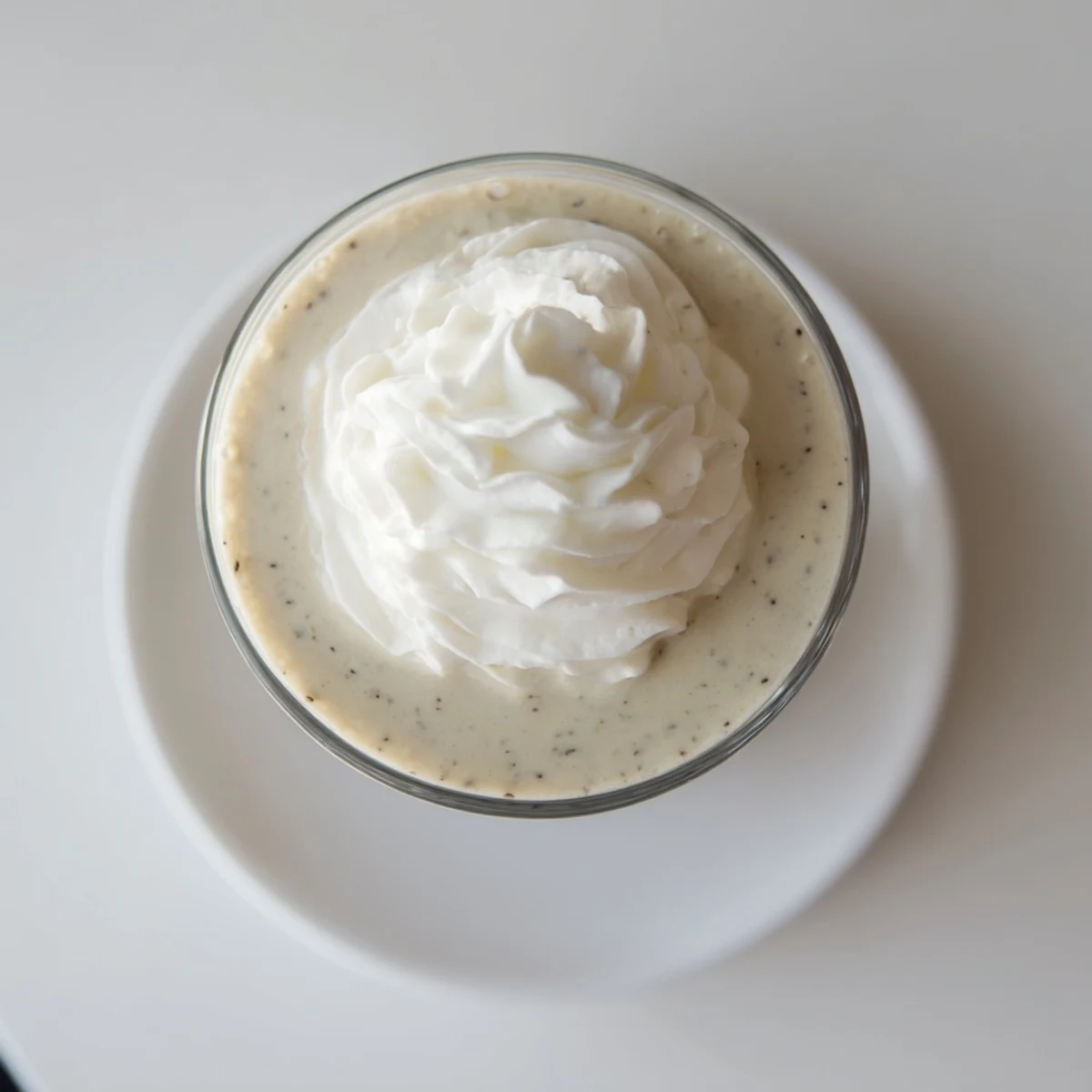 A frosted glass of Starbucks Vanilla Bean Frappuccino with a straw, offering a sweet, refreshing treat on a hot day.