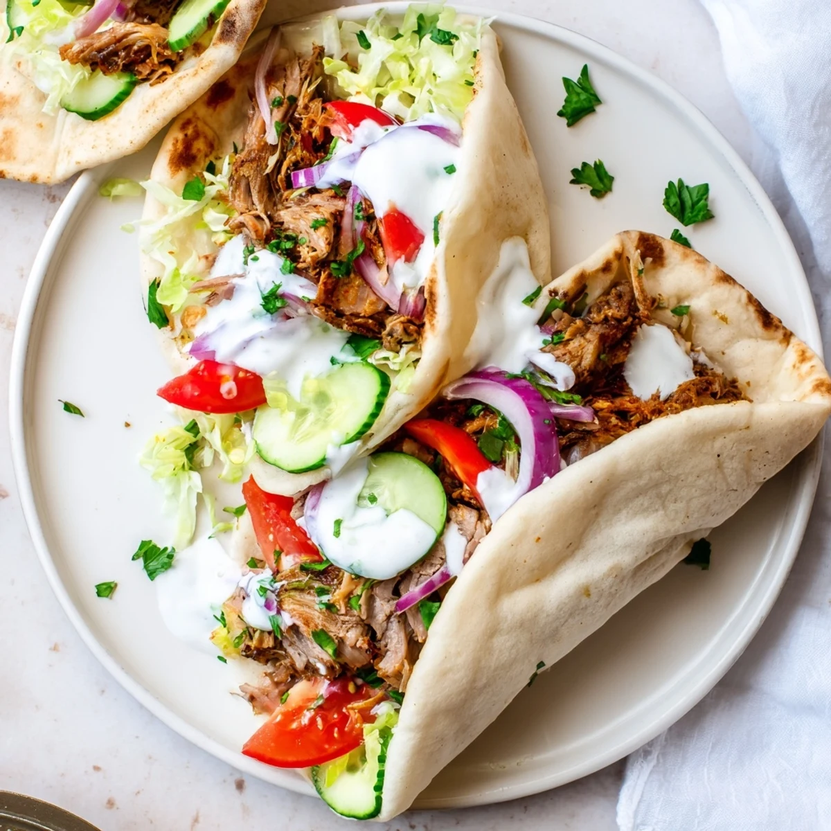 Plated Homemade Doner Kebab featuring tender lamb slices, vibrant red onions, cucumbers, and herbs, ready to be enjoyed as a meal.