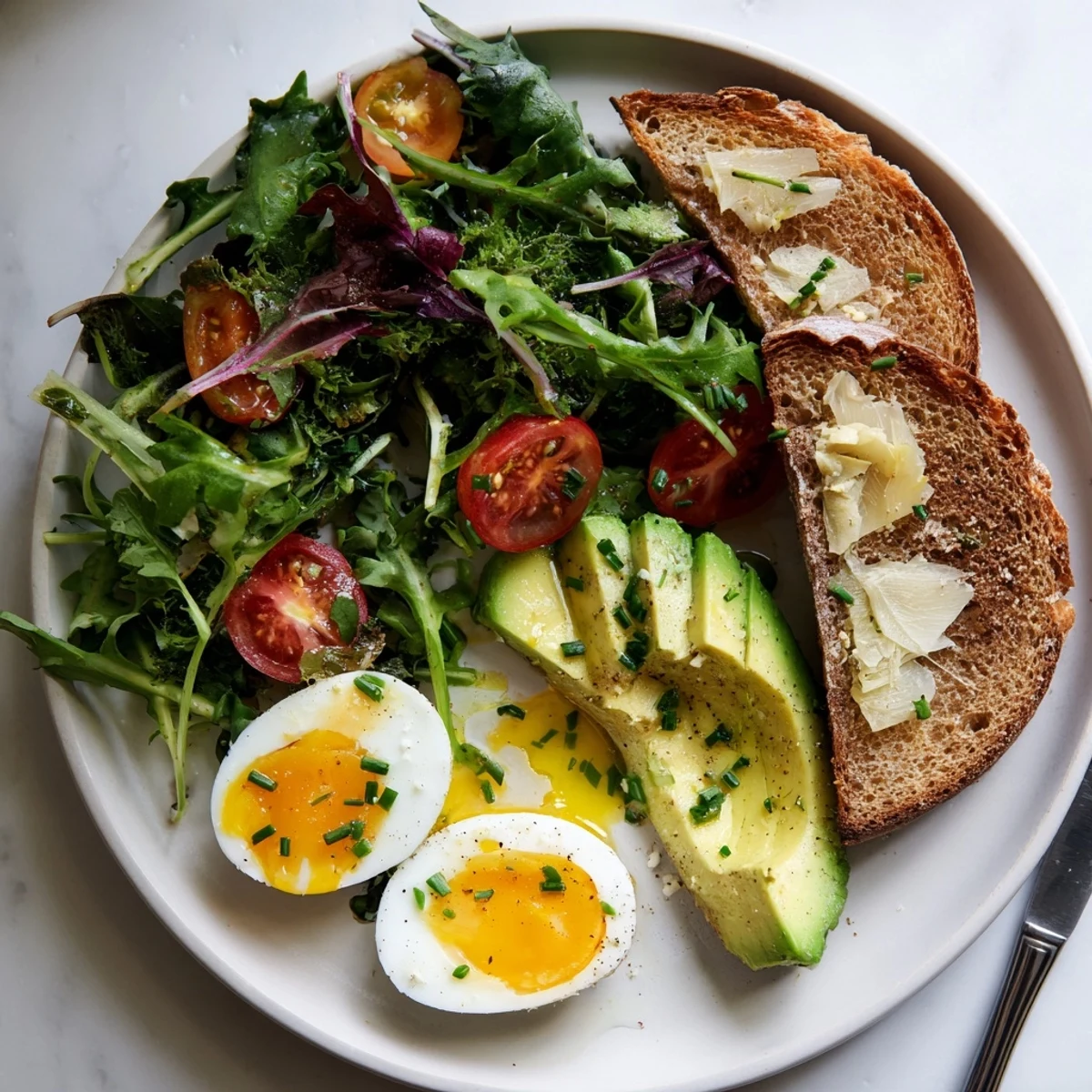 Savory Breakfast Plate with Soft Eggs, Toast & Greens served with lemony dressing and fresh herbs.