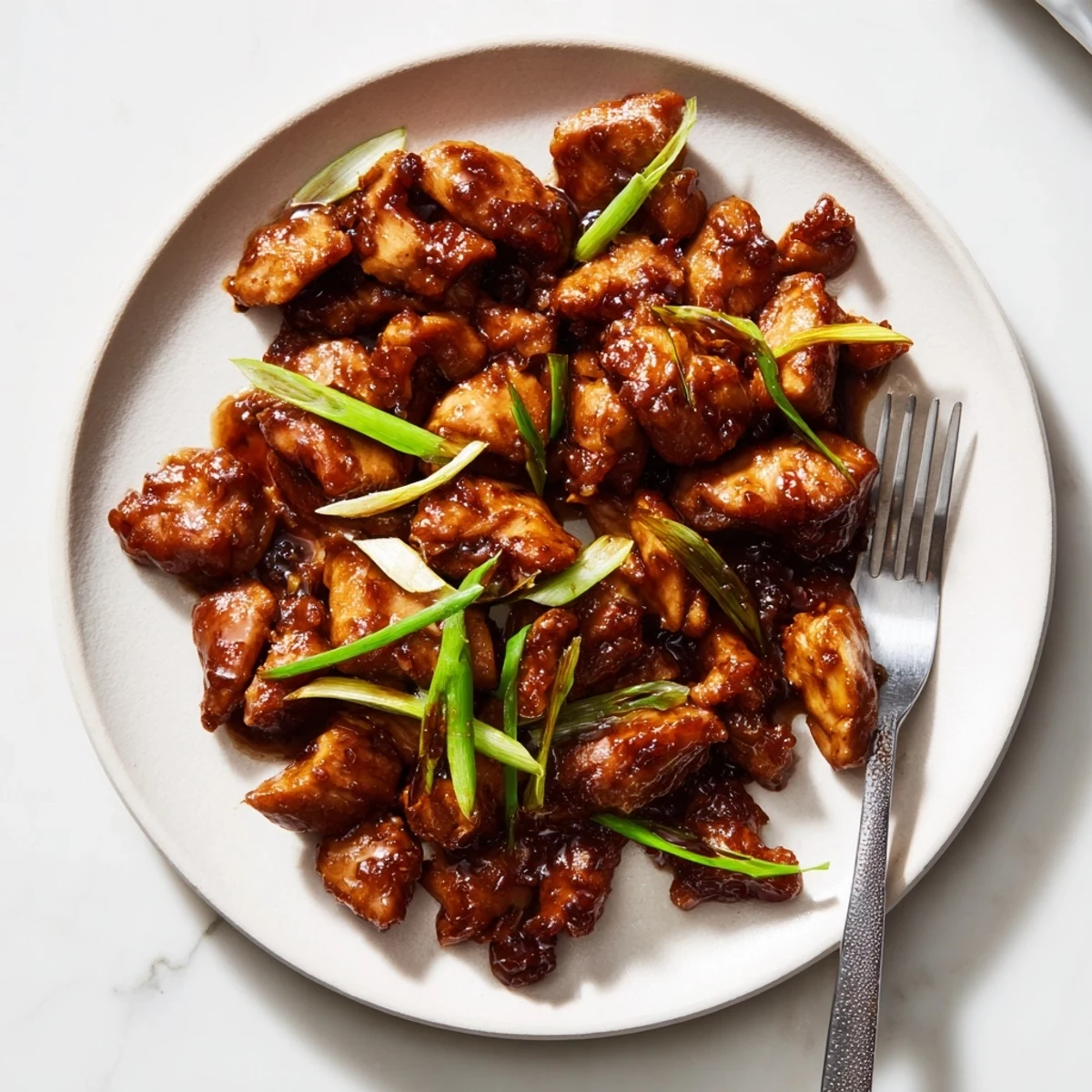 Golden brown Mongolian chicken pieces glazed in sticky sweet savory soy garlic sauce