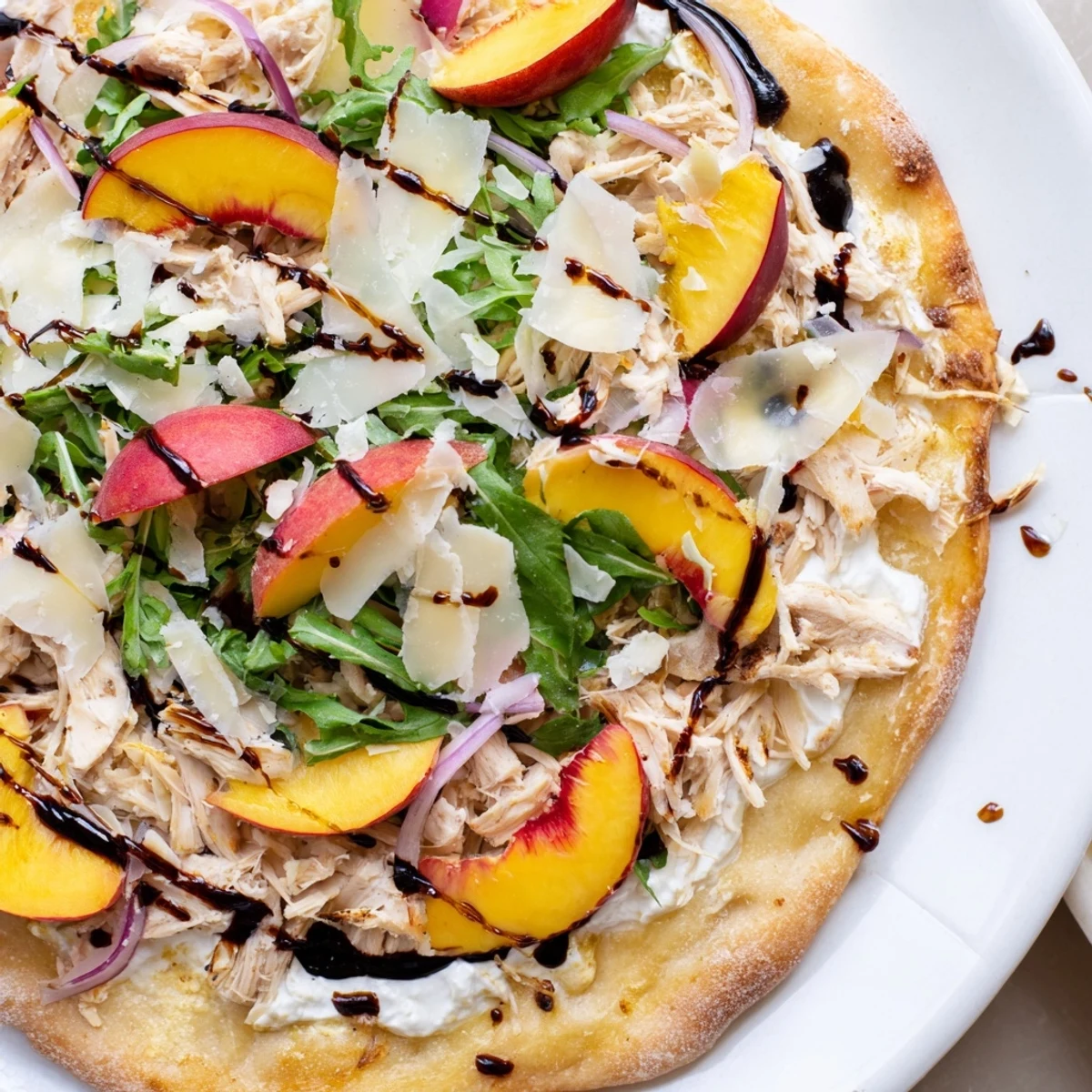 Summer pizza featuring juicy peaches, chicken, and creamy ricotta on crispy crust