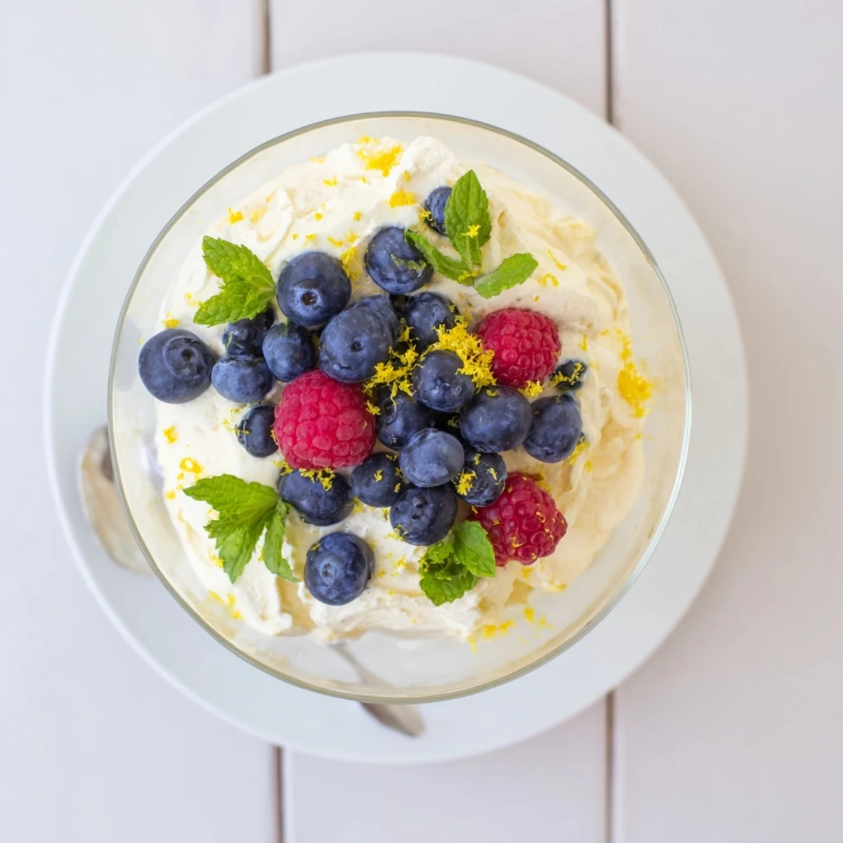 Tangy no bake lemon mascarpone mousse garnished with lemon zest and berries