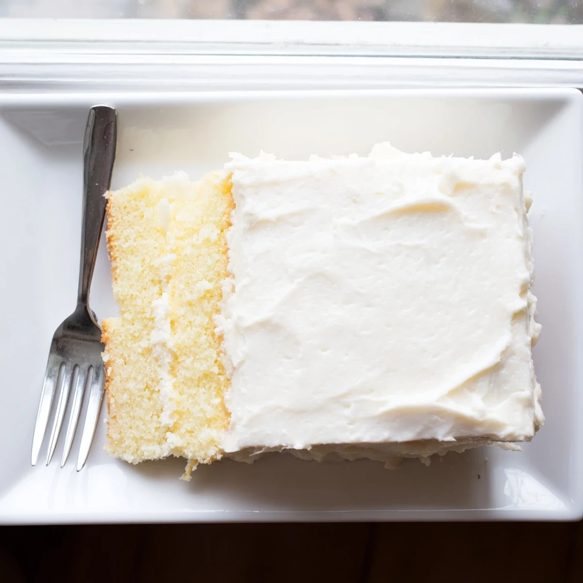 Light vanilla church cake slice revealing tender crumb topped with sweet frosting