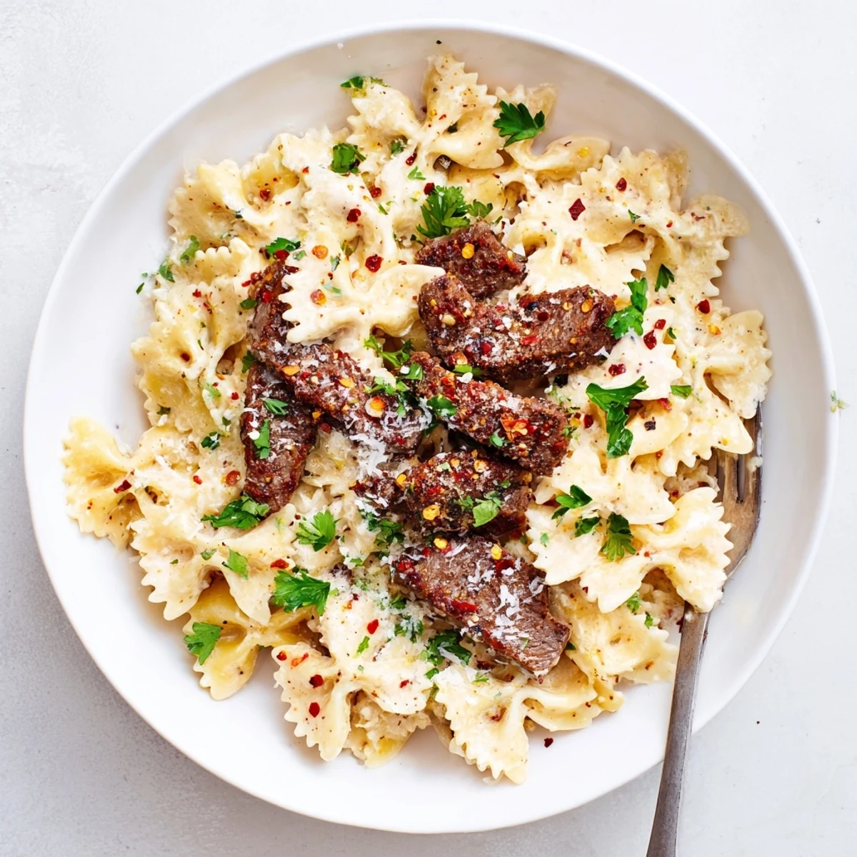 Creamy Cajun Alfredo bowtie pasta tossed with spice-rubbed beef in a rich, velvety white sauce