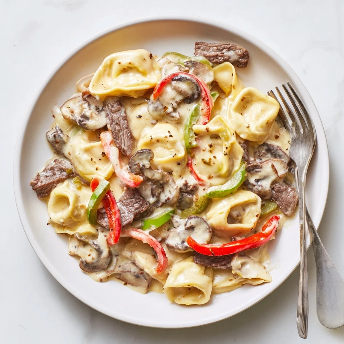Creamy Crock Pot Cheesesteak Tortellini with tender beef slices and melted provolone cheese in a rich sauce