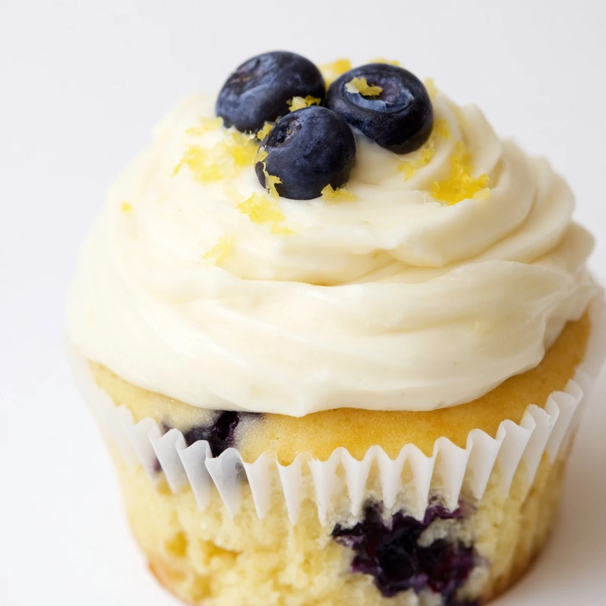 Golden lemon blueberry cupcakes topped with fluffy lemon cream cheese frosting and fresh blueberry garnish