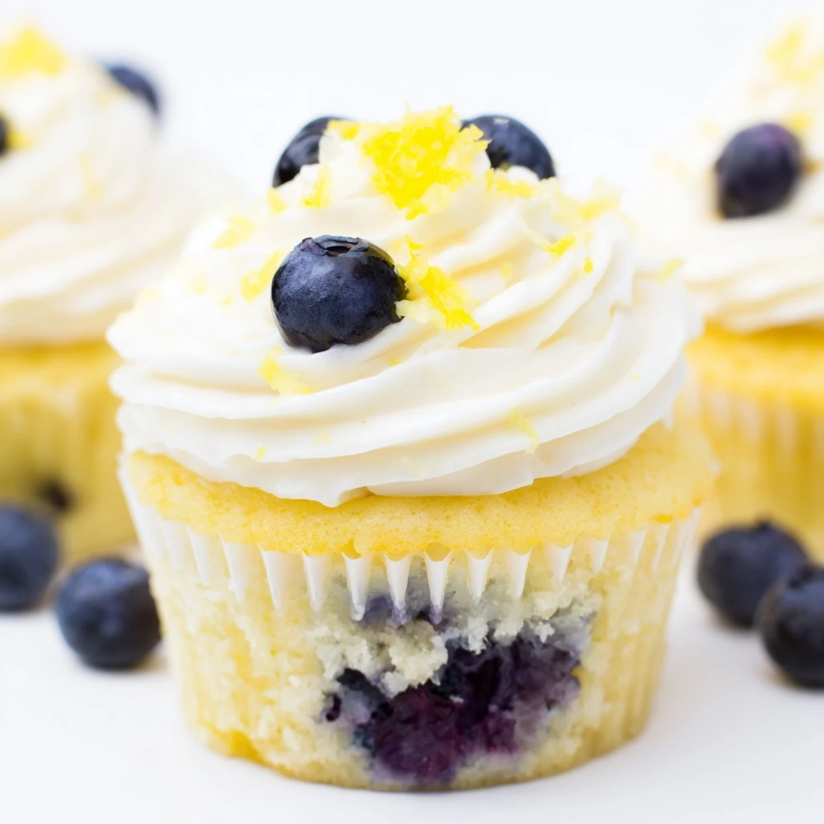 Baked lemon blueberry cupcakes with swirls of creamy lemon frosting and plump blueberries