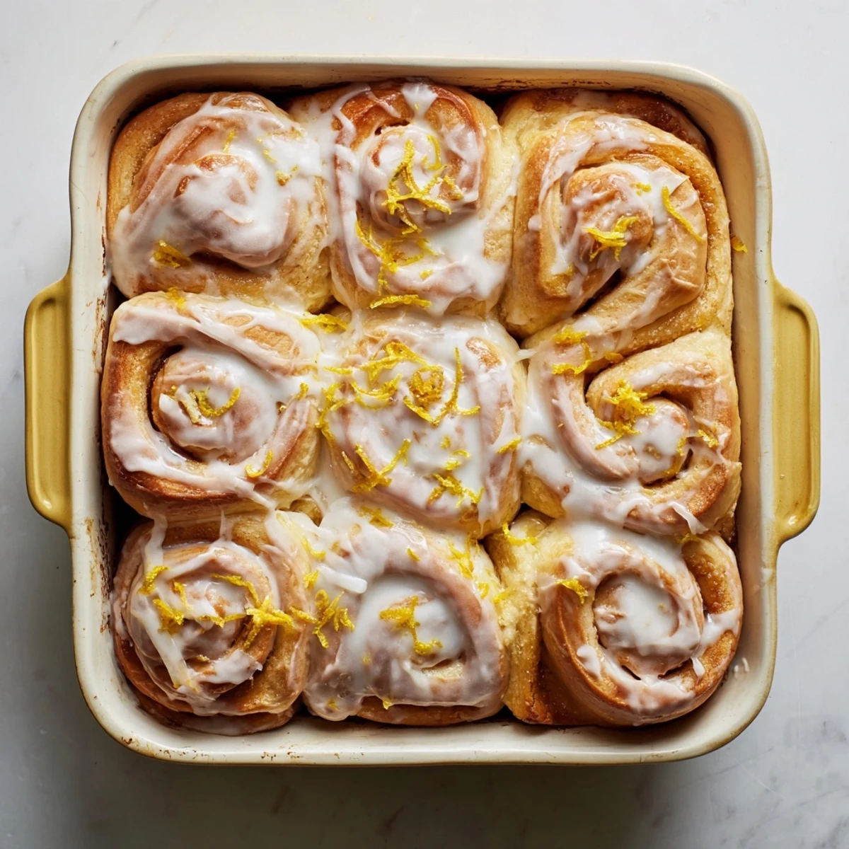 Fresh lemon rolls swirled with bright zest and topped with creamy powdered sugar glaze