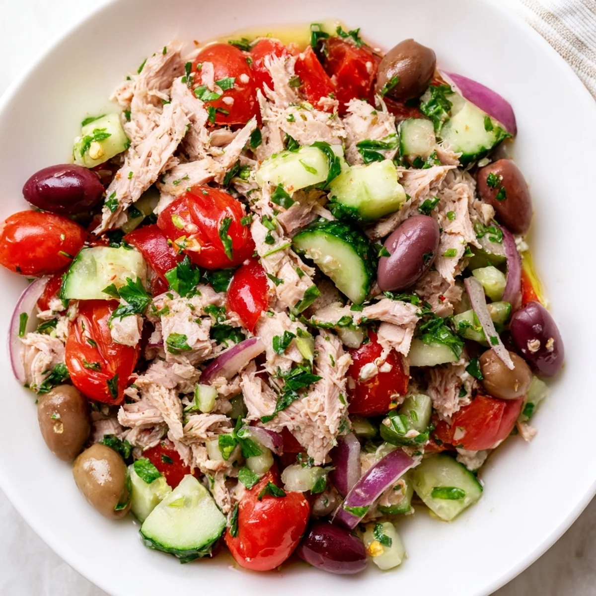 Colorful Mediterranean tuna salad in a rustic bowl with cherry tomatoes, olives, and fresh herbs