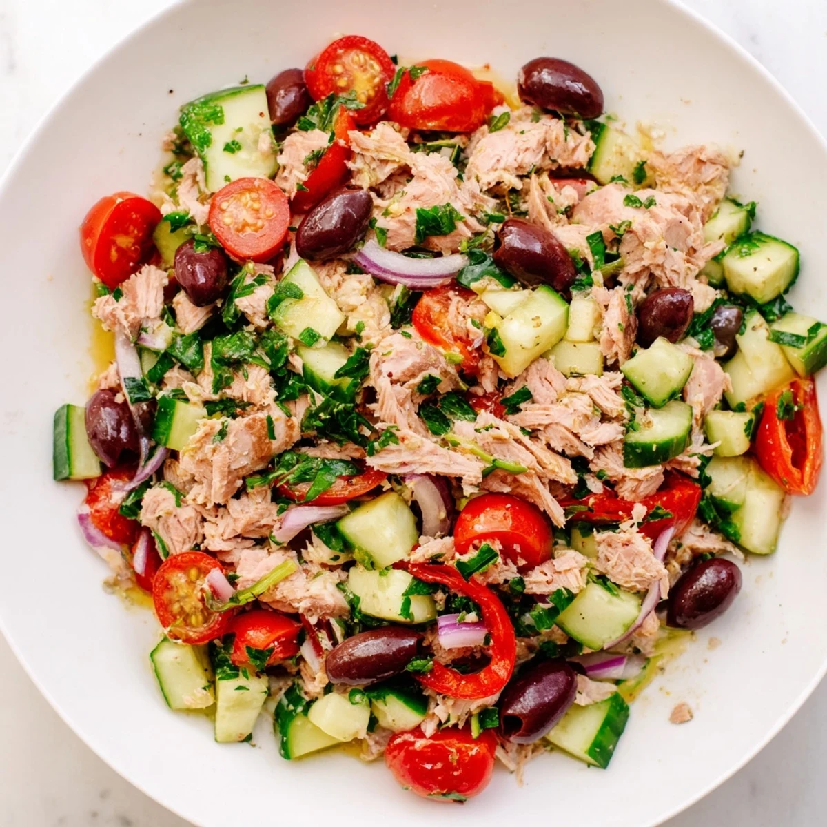Flaky tuna tossed with crisp cucumbers, roasted peppers, and tangy lemon dressing in a serving bowl