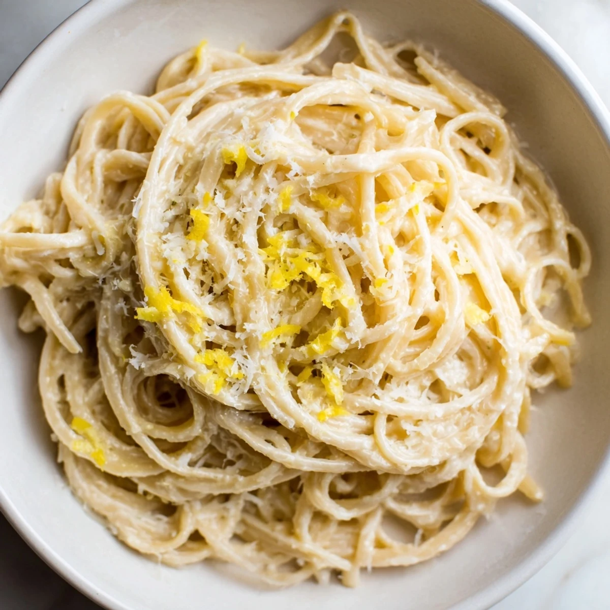 Creamy Parmesan lemon pasta twirled on a fork with fresh herb garnish