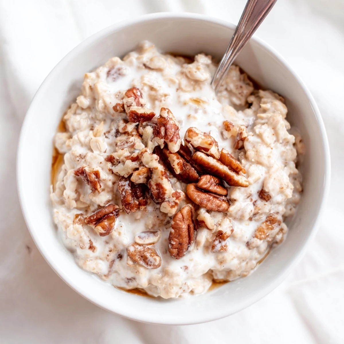 Maple cinnamon pecan overnight oats topped with crunchy pecans and a drizzle of syrup