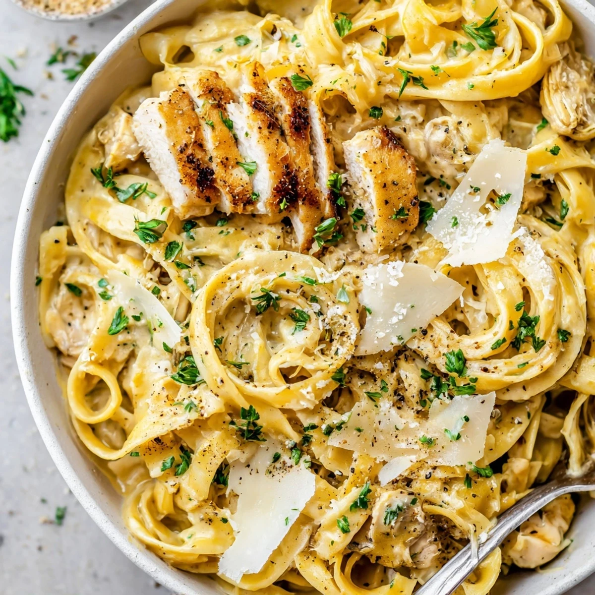 Creamy Garlic Chicken Pasta with tender sliced chicken, steaming al dente fettuccine