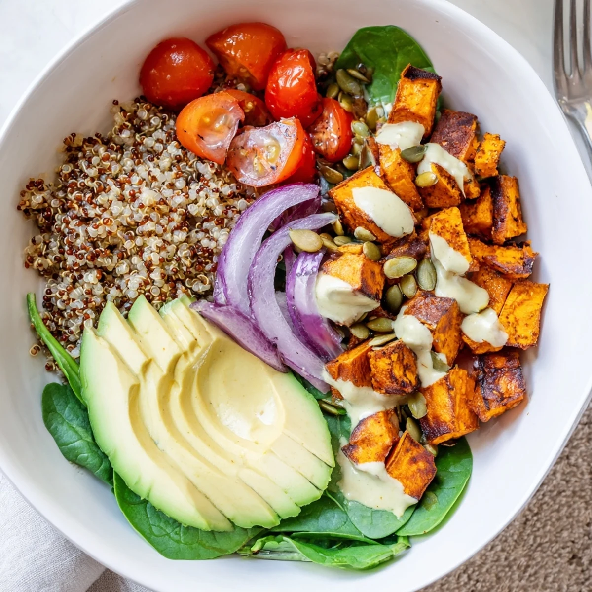 Fork-ready Roasted Sweet Potato Quinoa Salad Bowl garnished with toasted seeds and herbs