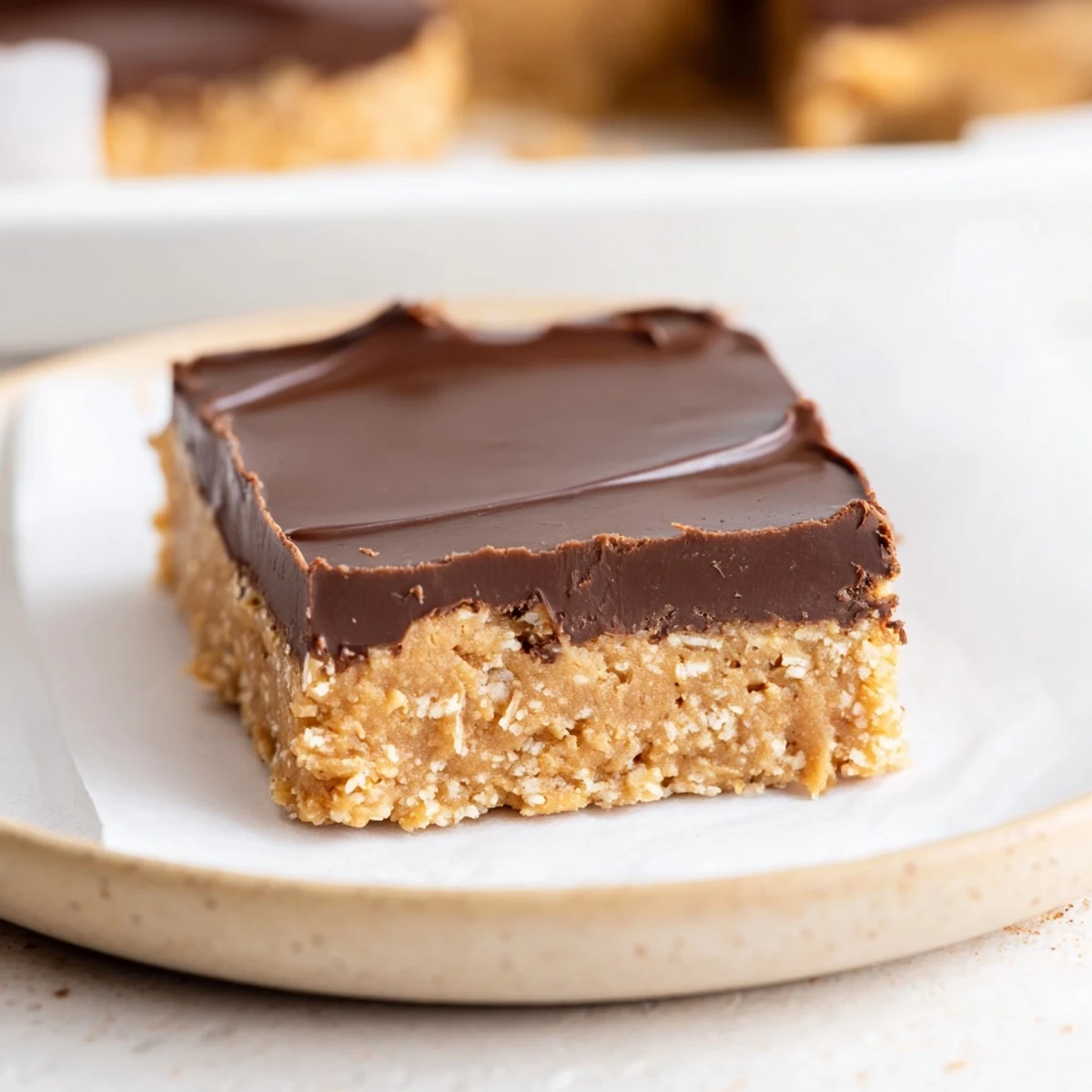 Slice of No Bake Peanut Butter Bars showing creamy center, crunchy graham base