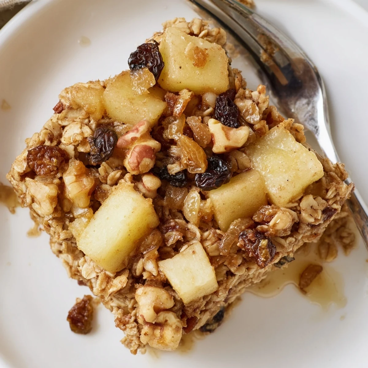 Slice of Delicious Apple Cinnamon Oatmeal Bake Recipe For Mornings served warm with yogurt.