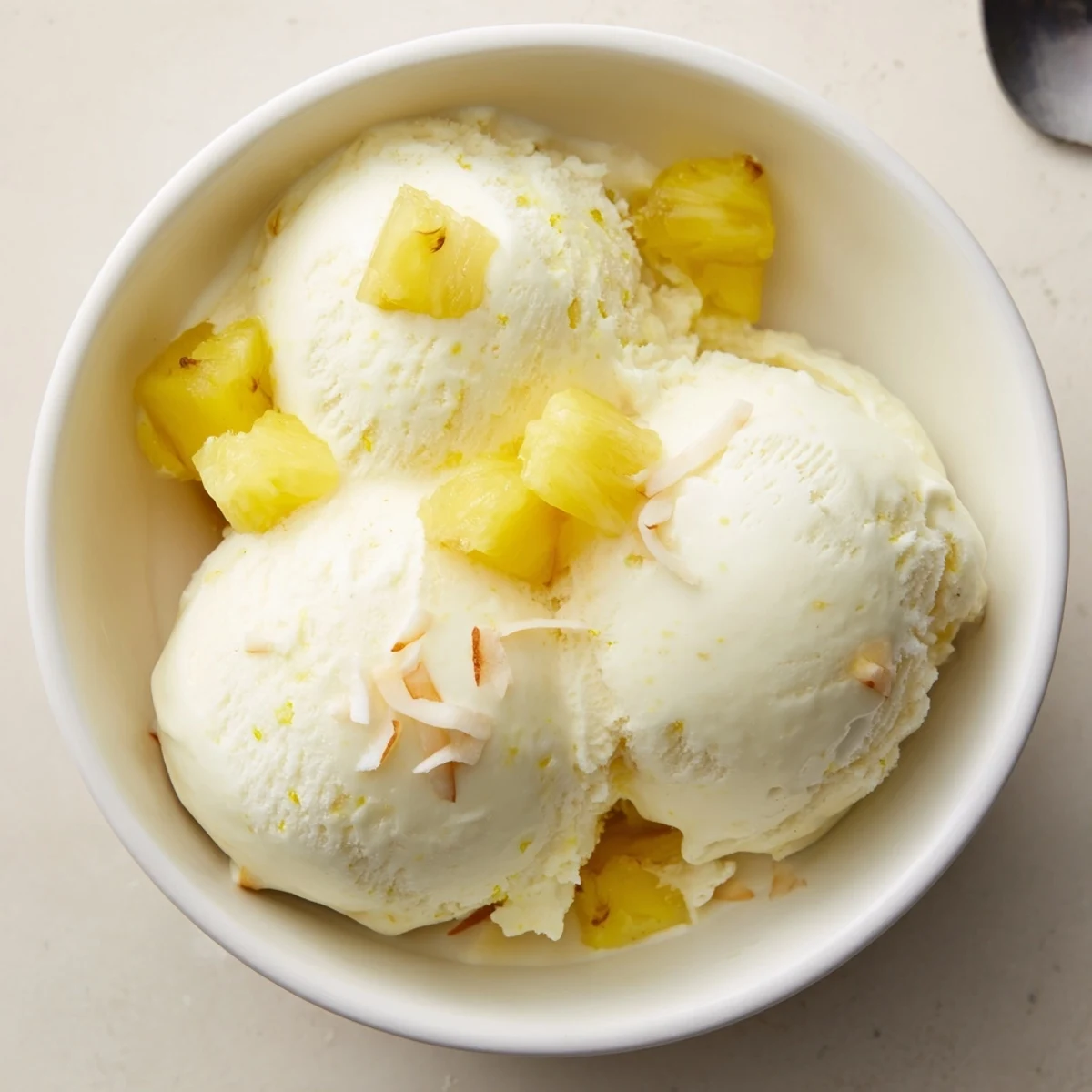 Chilled Creamy Pineapple Ice Cream nestled beside toasted coconut for summer