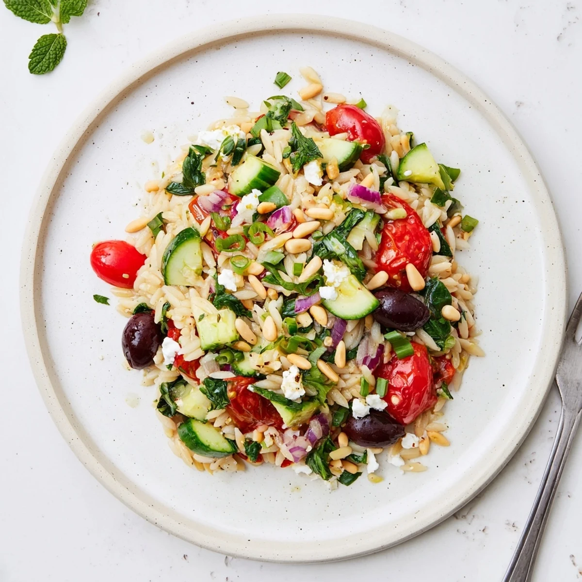 Colorful Mediterranean orzo power salad loaded with fresh vegetables, feta cheese, and lemon-oregano vinaigrette