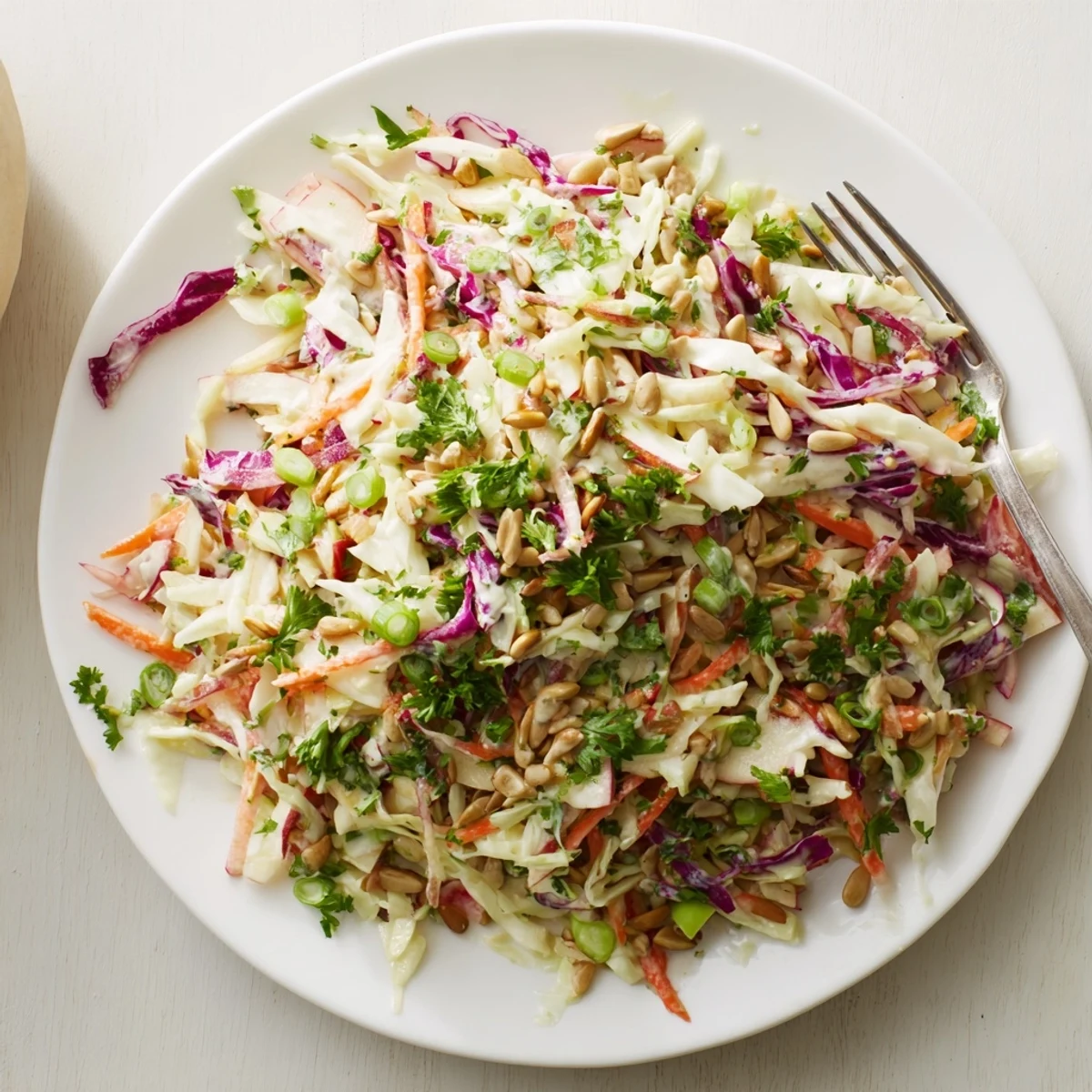 Golden apple coleslaw in white bowl showcasing crunchy cabbage and tangy honey-mustard dressing