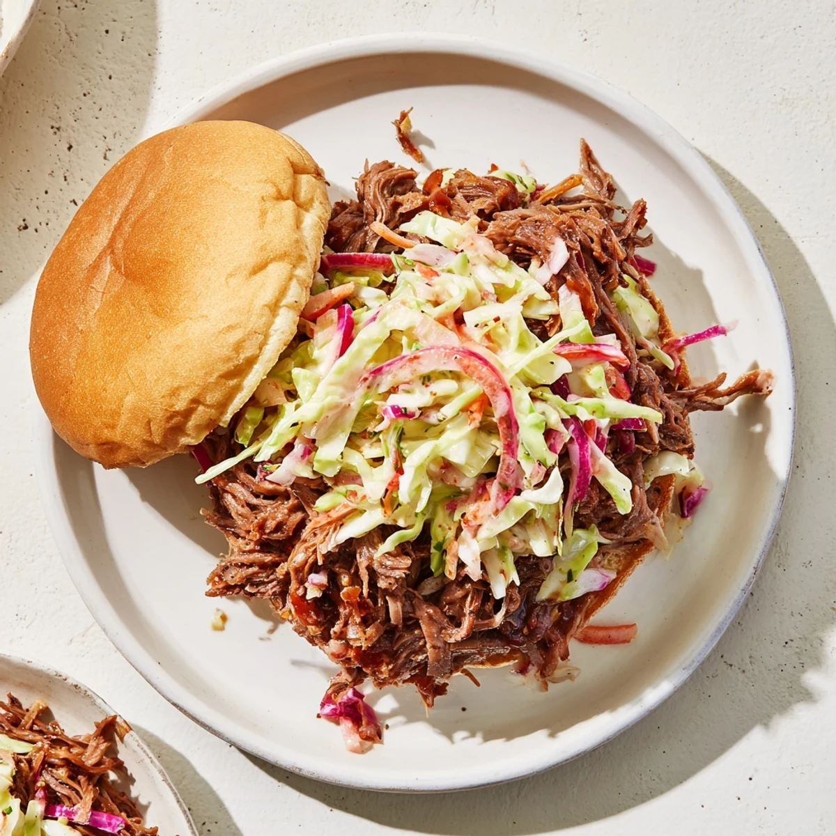 Tender smoky BBQ beef sandwiches piled high on toasted buns with crisp colorful coleslaw