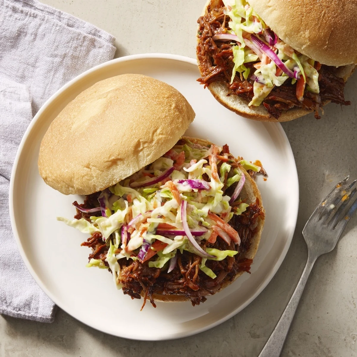 Homemade smoky beef sandwiches featuring melt-in-your-mouth meat and fresh slaw on golden buns