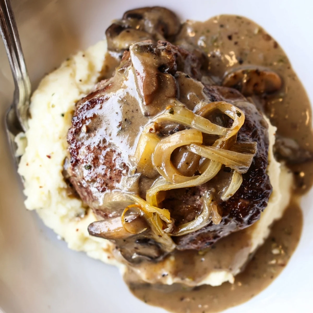 Country Style Smothered Cube Steak Recipe with seared edges, savory onion-mushroom gravy