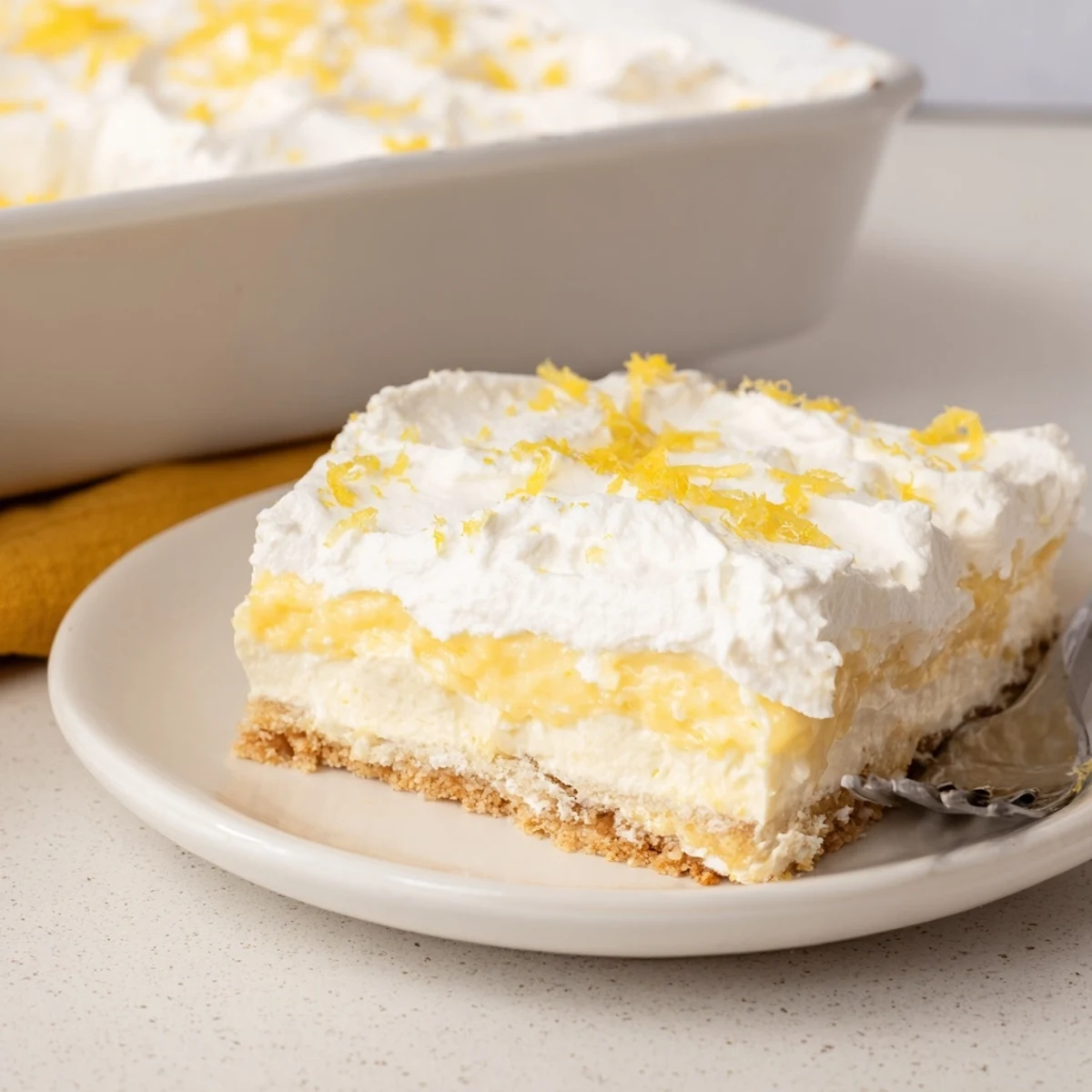 Lemon Lush Cake with creamy lemon layer and fluffy whipped topping, chilled.