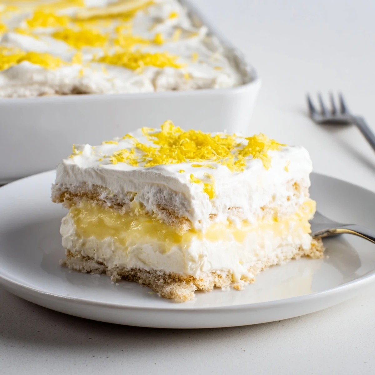 Sliced Lemon Lush Cake on a serving plate, zesty aroma and cool silky filling.
