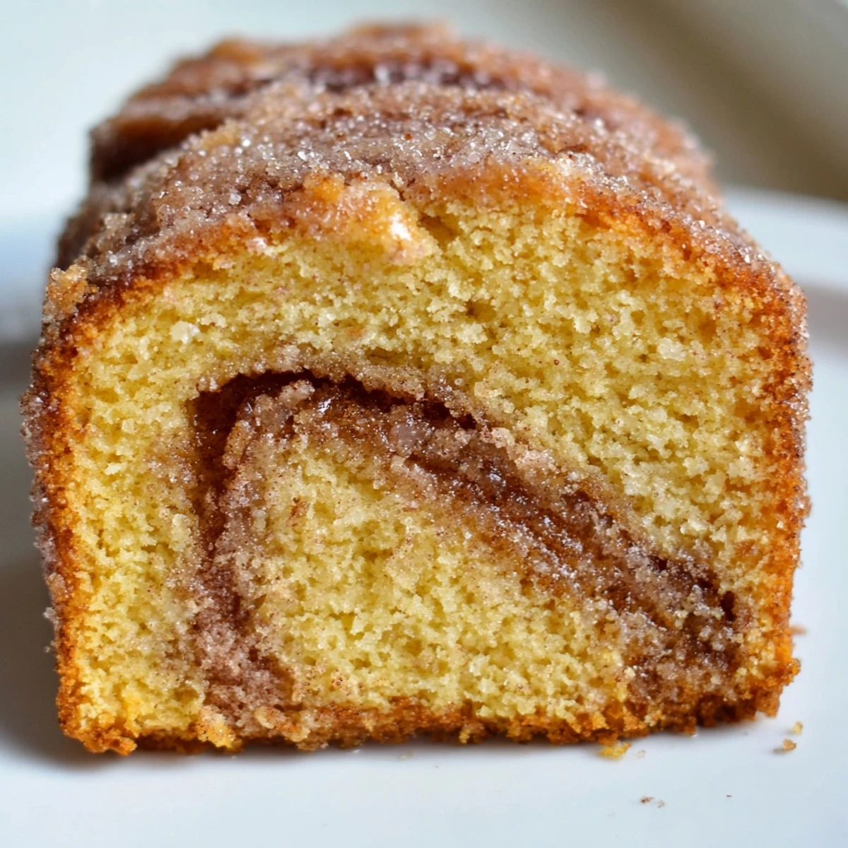 Golden cinnamon donut loaf sliced on a rustic wooden cutting board
