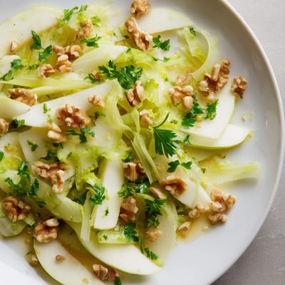 Bright Apple and Celery Salad with Walnuts showcases crisp apples and celery topped with crunchy toasted walnuts and fresh parsley on a white platter.  